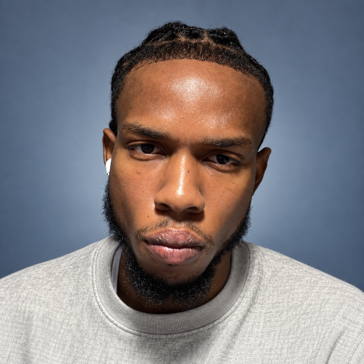 Najae Hall wearing a gray sweatshirt against a blue-gray background
